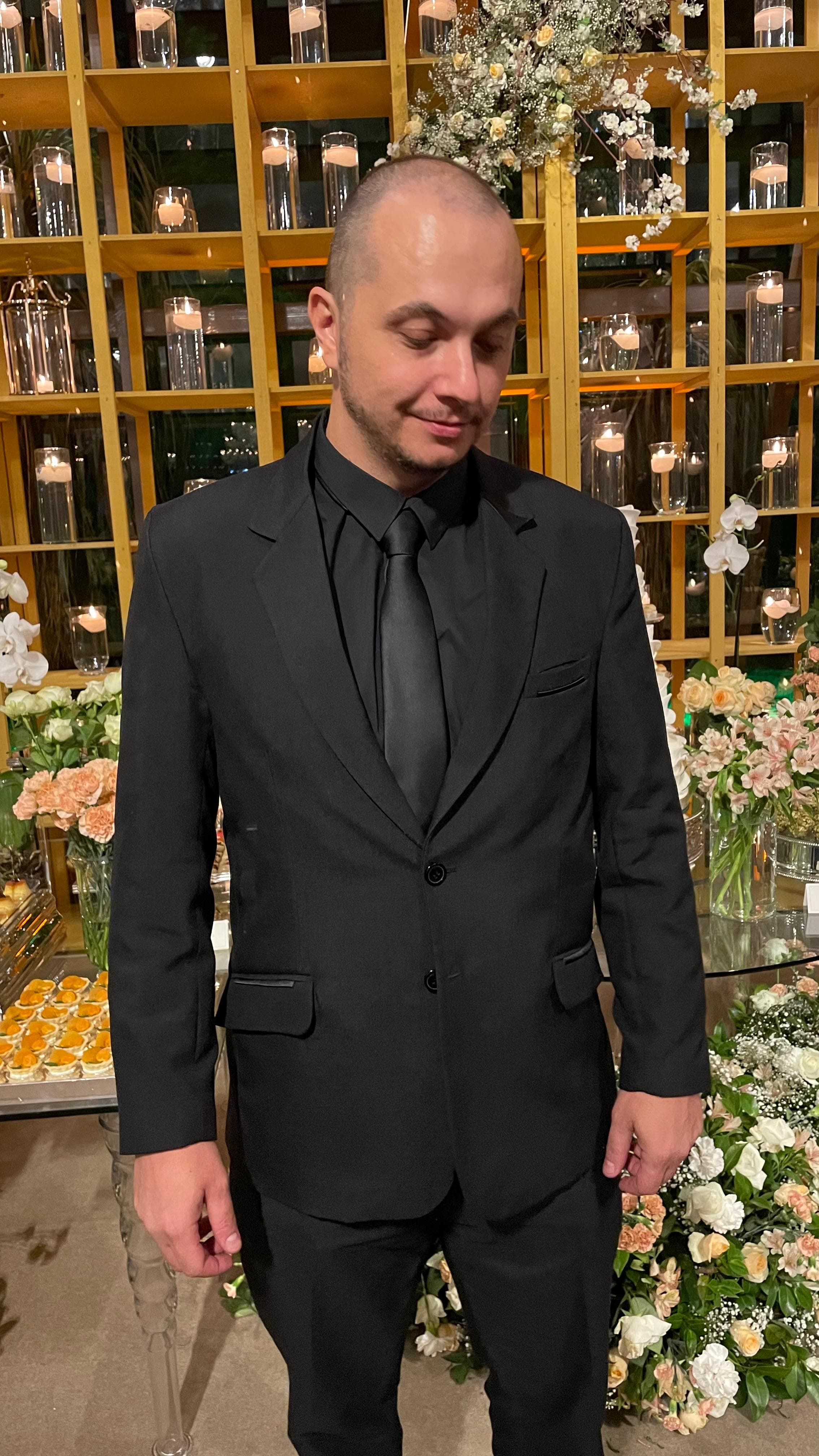 Interior da Alfaiataria Figueiredo, corredor com roupas penduradas e provador ao fundo